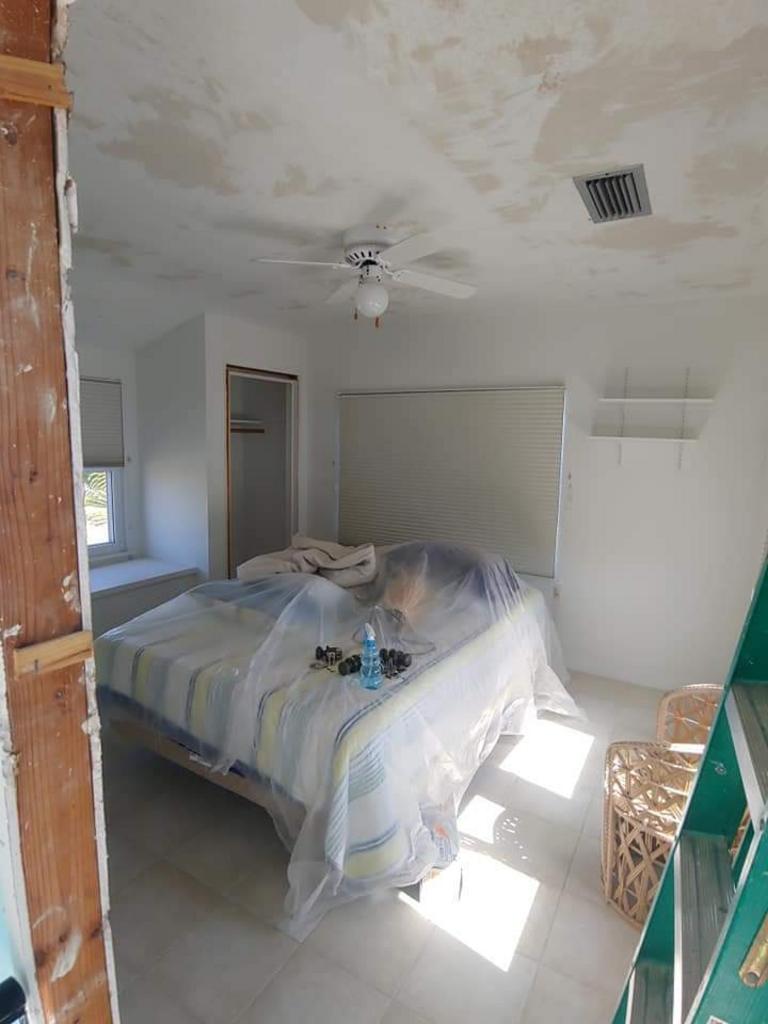 A bedroom with a bed and a ceiling fan.