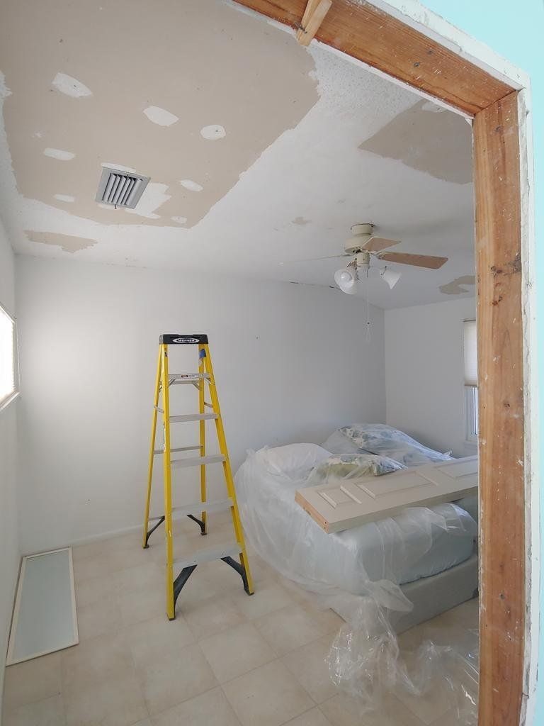 A yellow ladder is sitting in a room next to a bed.