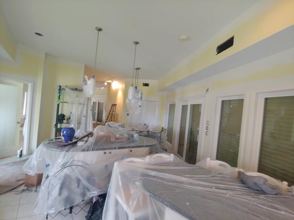 A kitchen is being painted and covered in plastic.