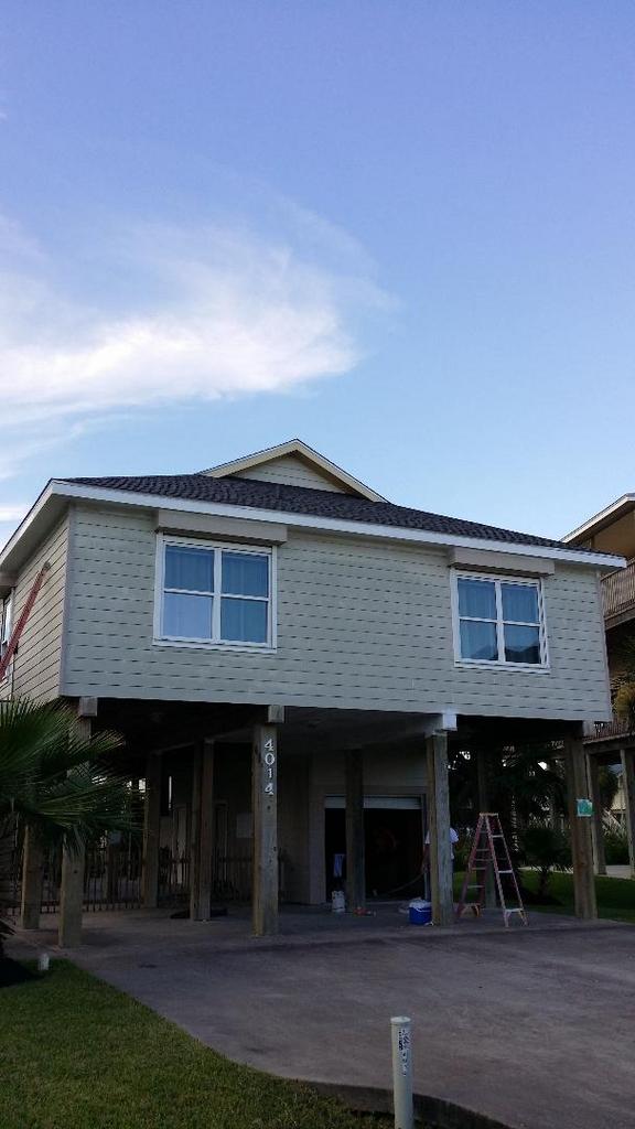 A house under construction with a blue sky in the background.