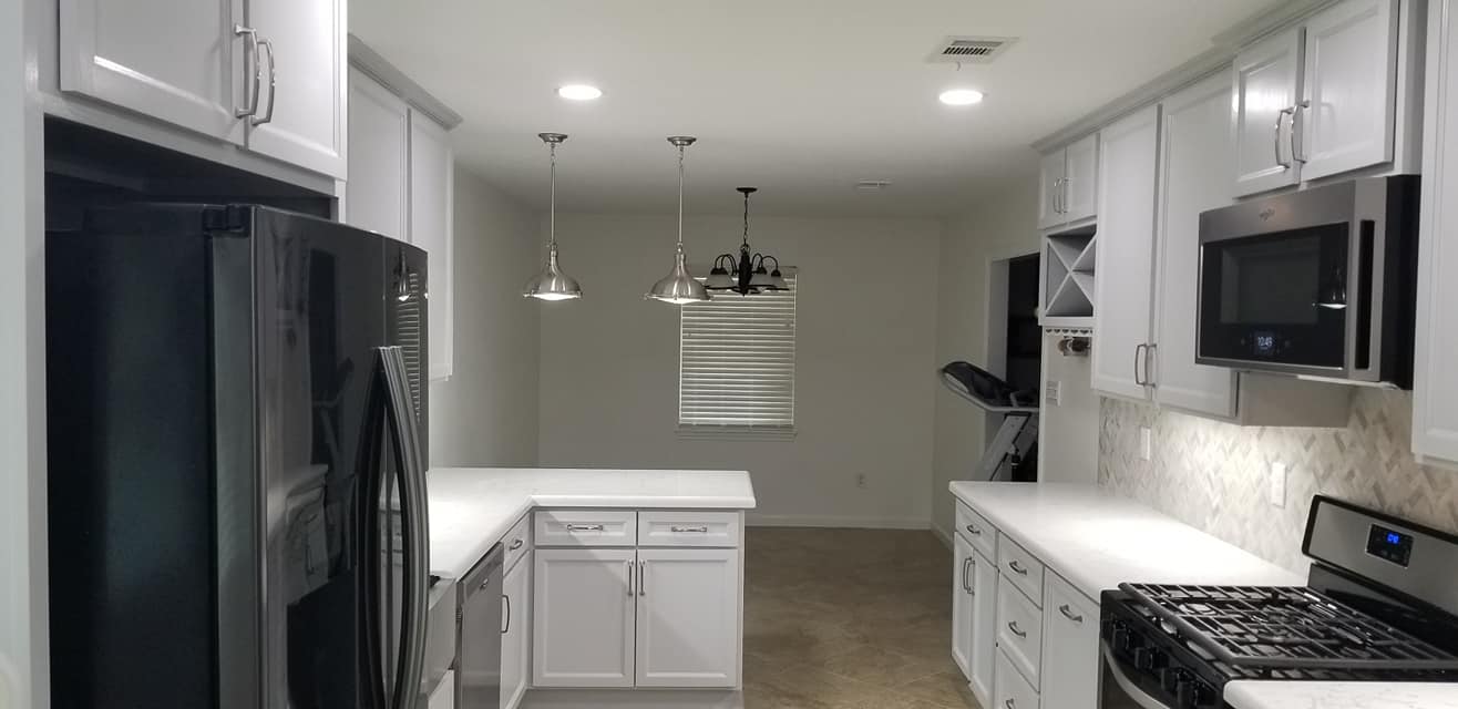 A kitchen with white cabinets and stainless steel appliances.