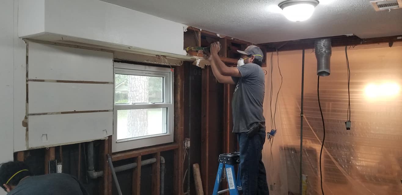 A man is standing on a ladder in a room.
