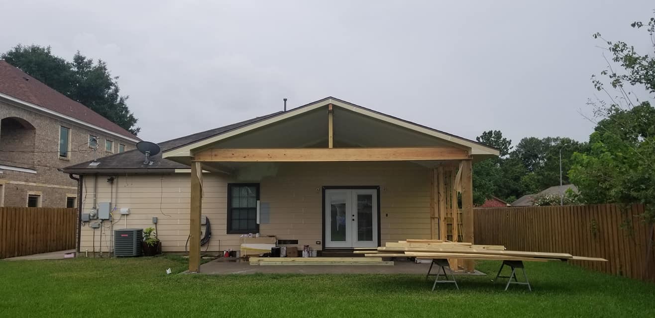 A house with a porch being built in the backyard.