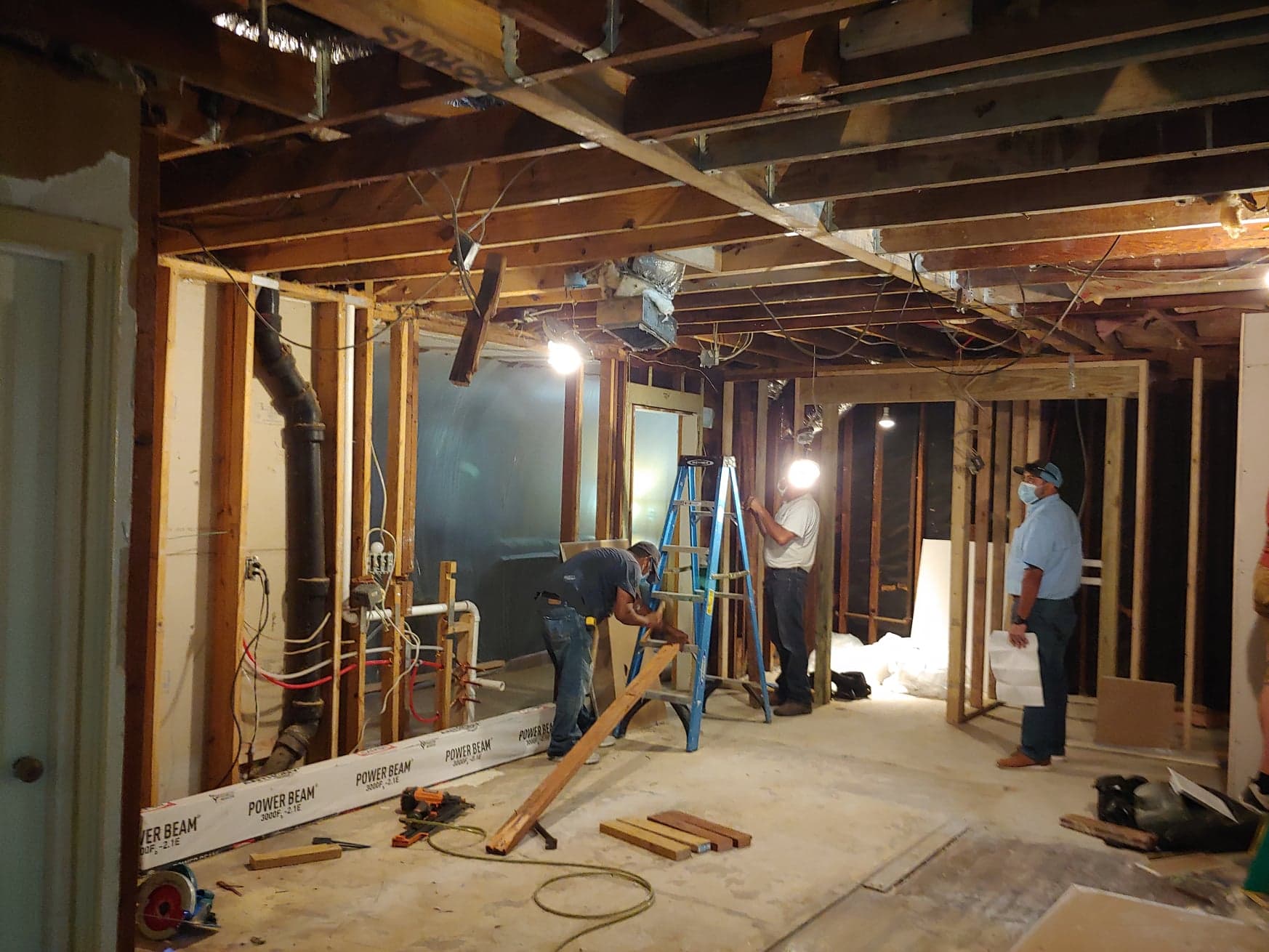 A group of men are working on a house under construction.
