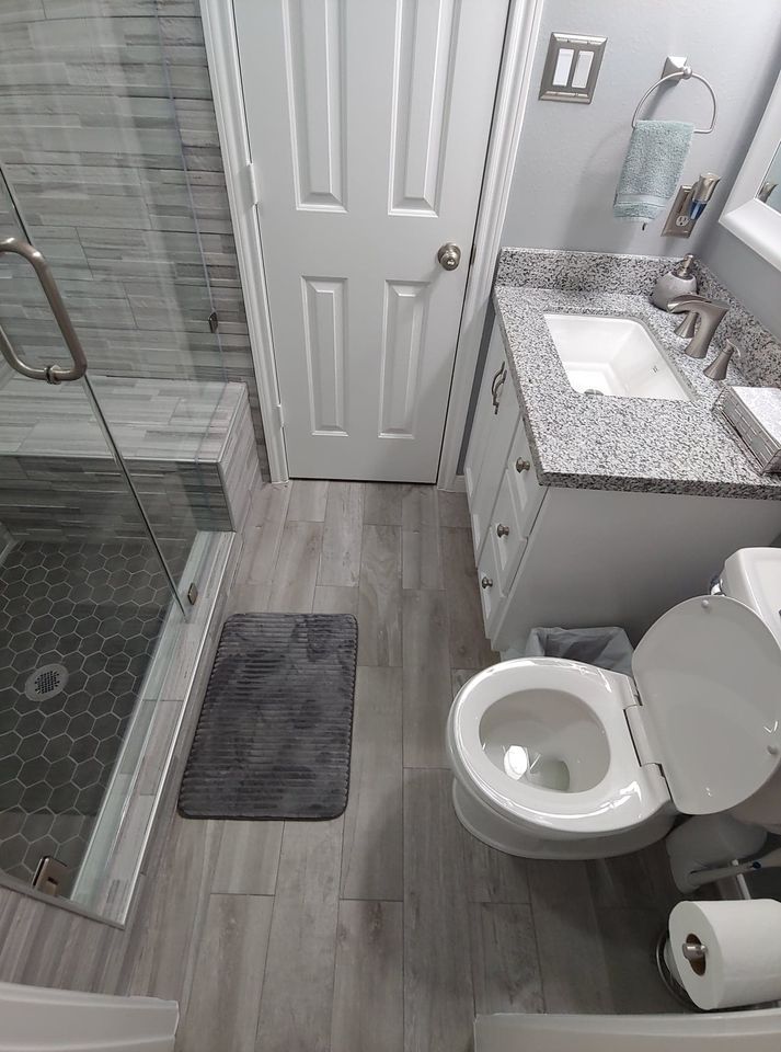 A bathroom with a toilet , sink , and shower.