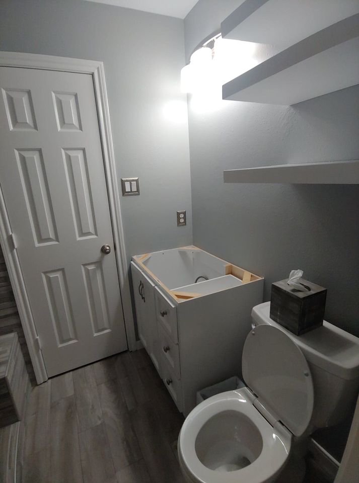 A bathroom with a toilet , sink , and bathtub.