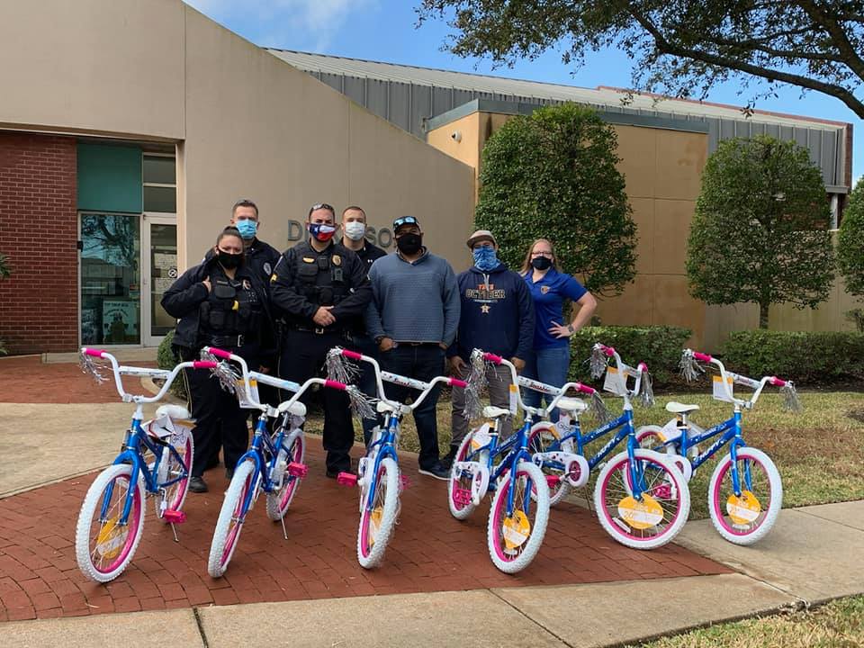 A group of people standing next to bicycles in front of a building.
