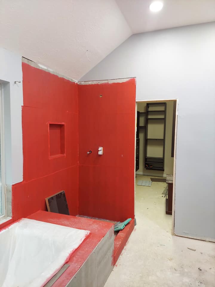A bathroom with red walls and a bathtub