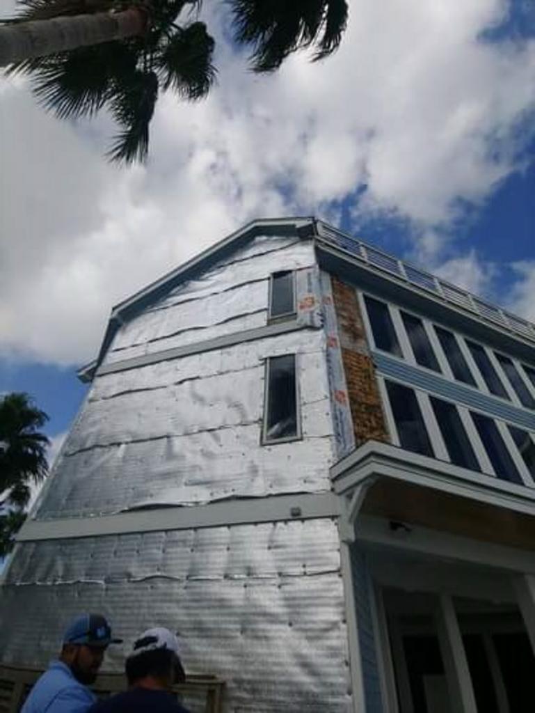 Two men are standing in front of a building that is being built.
