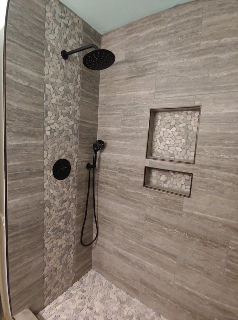 A shower with a shower head and two niches on the wall.