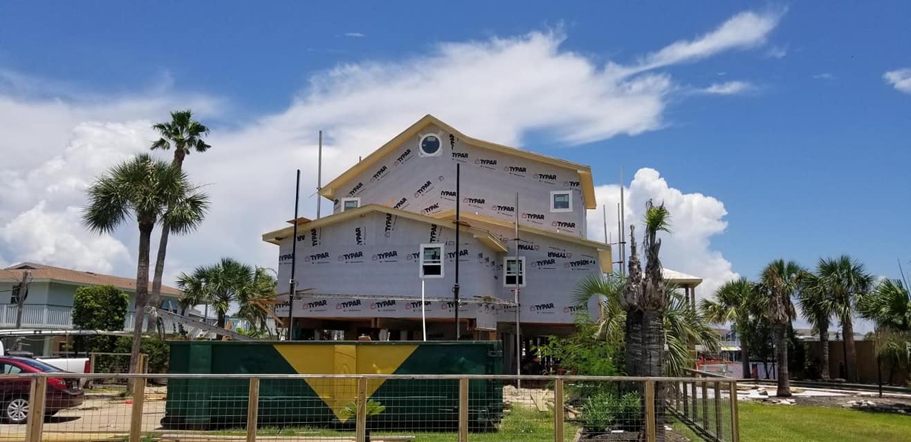 A house is being built on stilts on a sunny day.