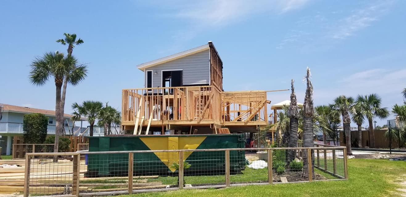 A house is being built in the middle of a lush green field.