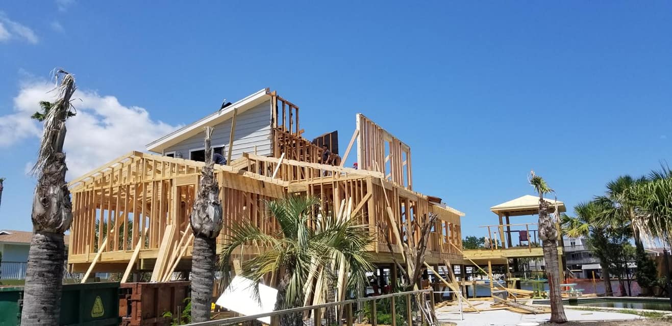 A large house is being built with a blue sky in the background.