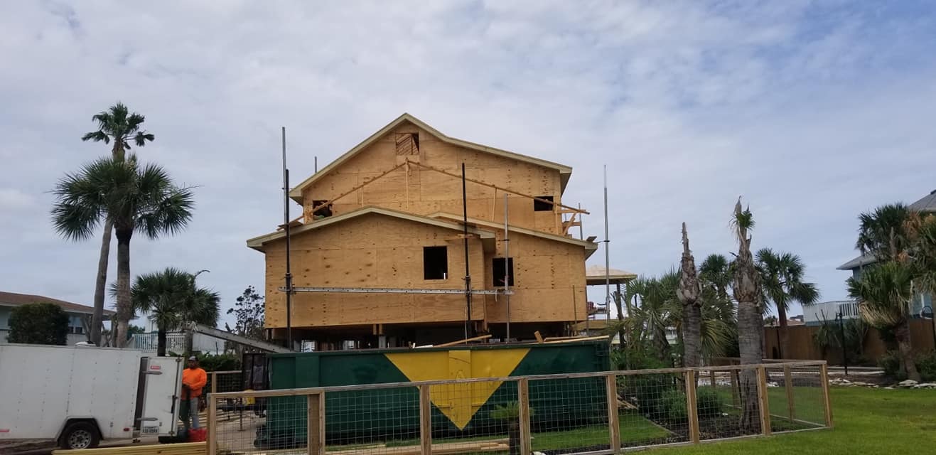 A house is being built on stilts in a yard.
