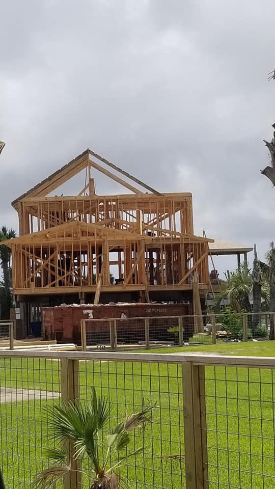 A house is being built in the middle of a grassy field.