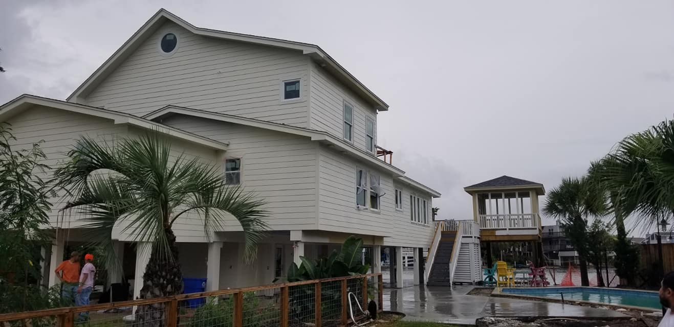 A large white house with a swimming pool in front of it.