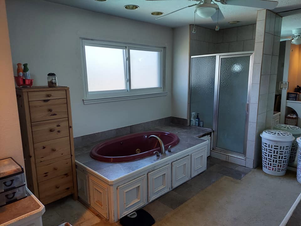 A bathroom with a bathtub and a shower.