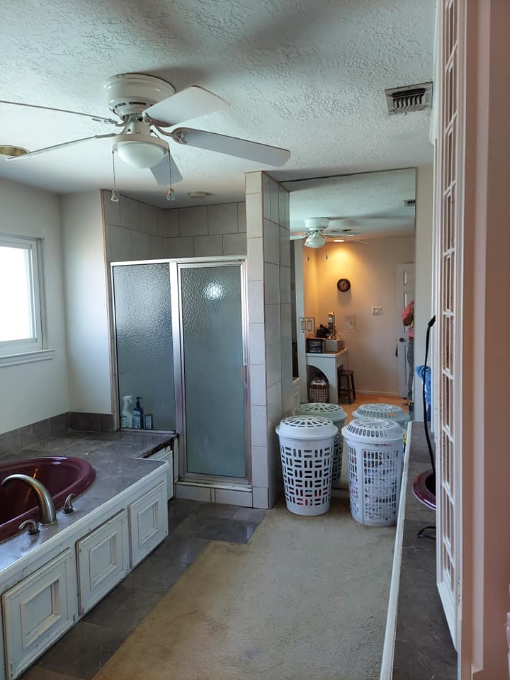 A bathroom with two laundry baskets and a ceiling fan