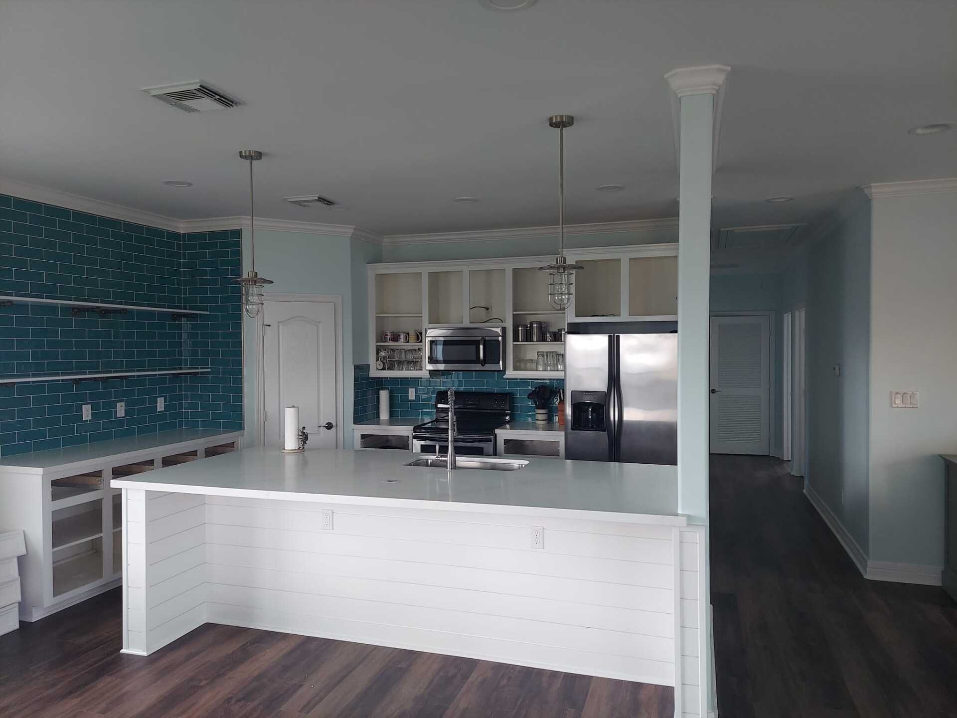 A kitchen with a large island and stainless steel appliances.
