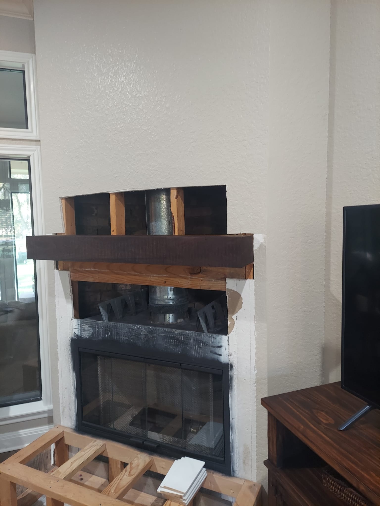 A fireplace is being remodeled in a living room.