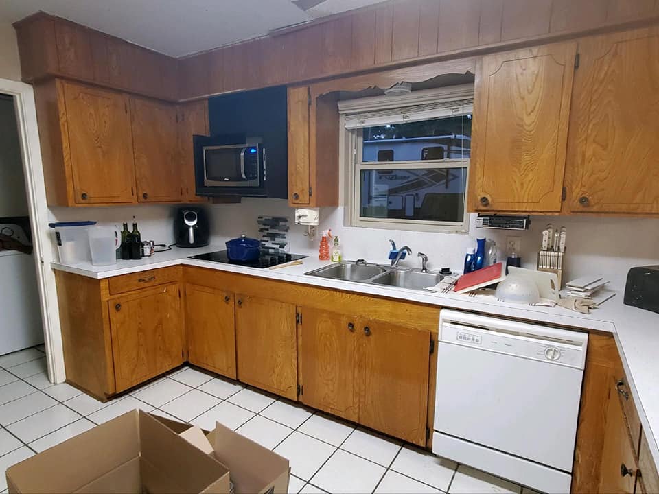 A kitchen with wooden cabinets and a white dishwasher