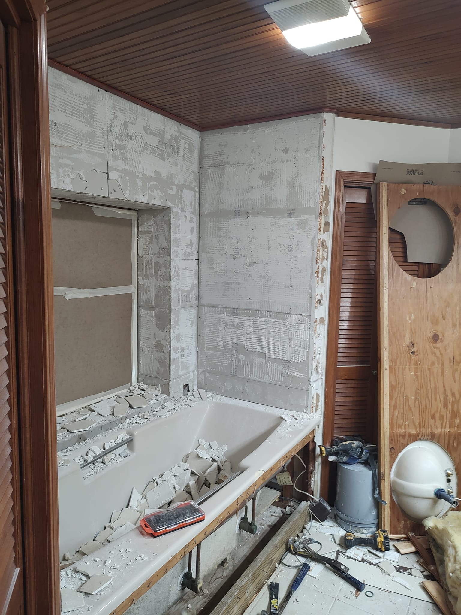 A bathroom is being remodeled with a bathtub in the middle of the room.