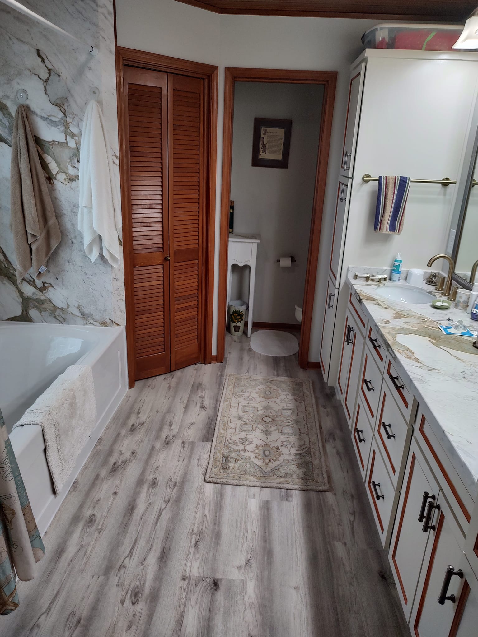 A bathroom with two sinks , a tub , and a mirror.