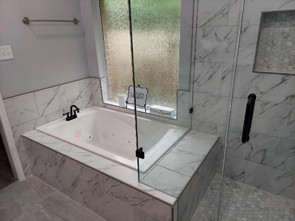 A bathroom with a bathtub and a shower stall.