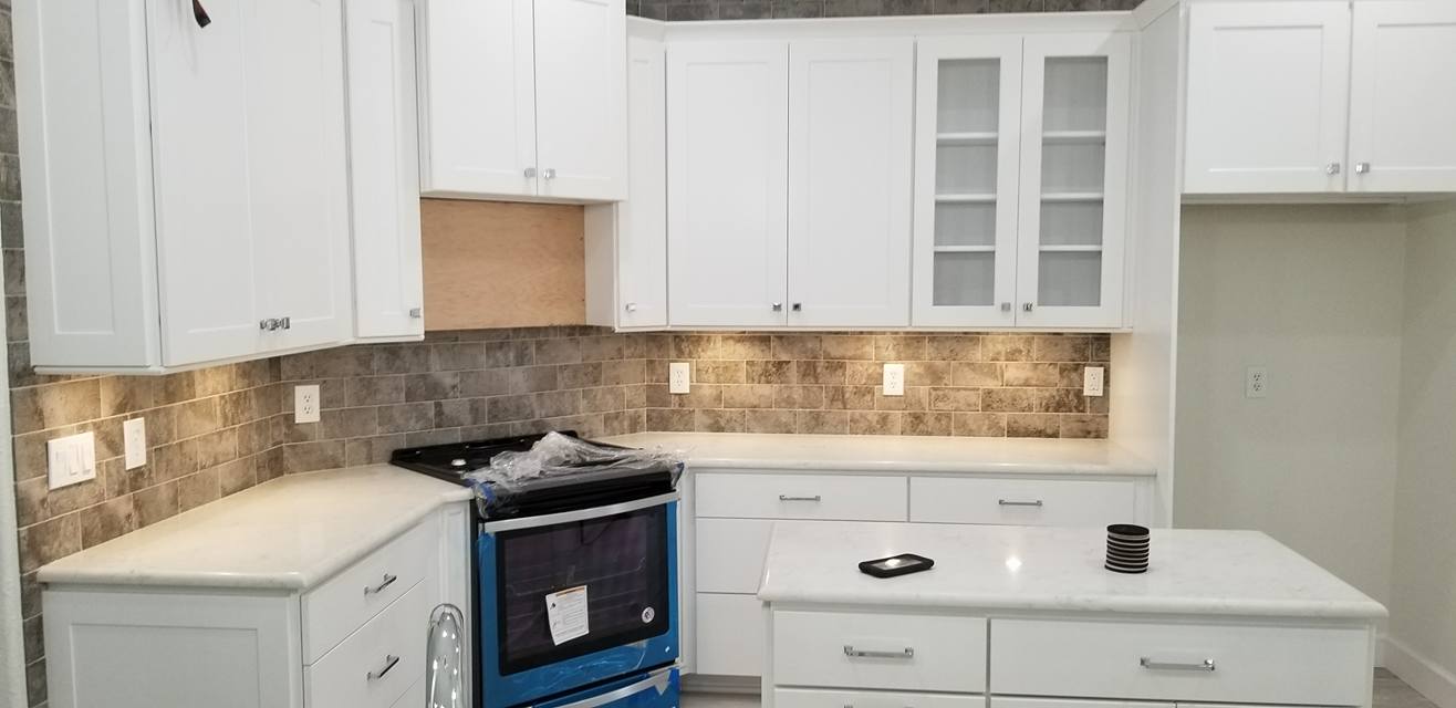 A kitchen with white cabinets and a blue stove.