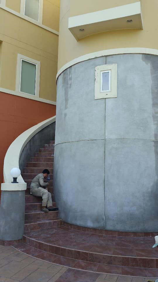 A man is sitting on a set of stairs in front of a building