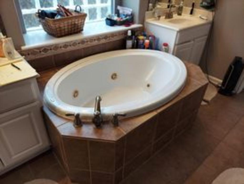 A bathroom with a jacuzzi tub and a sink.