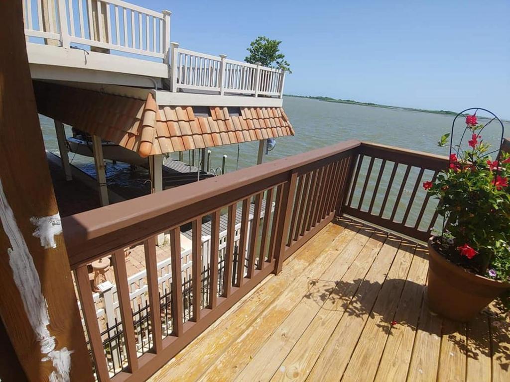 A wooden deck with a railing overlooking a body of water