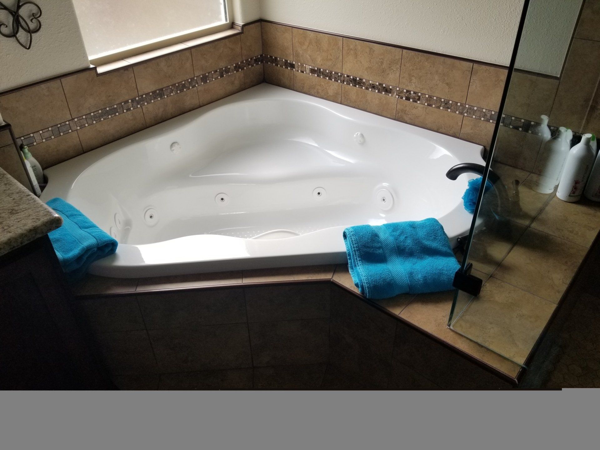 A bathroom with a jacuzzi tub and blue towels