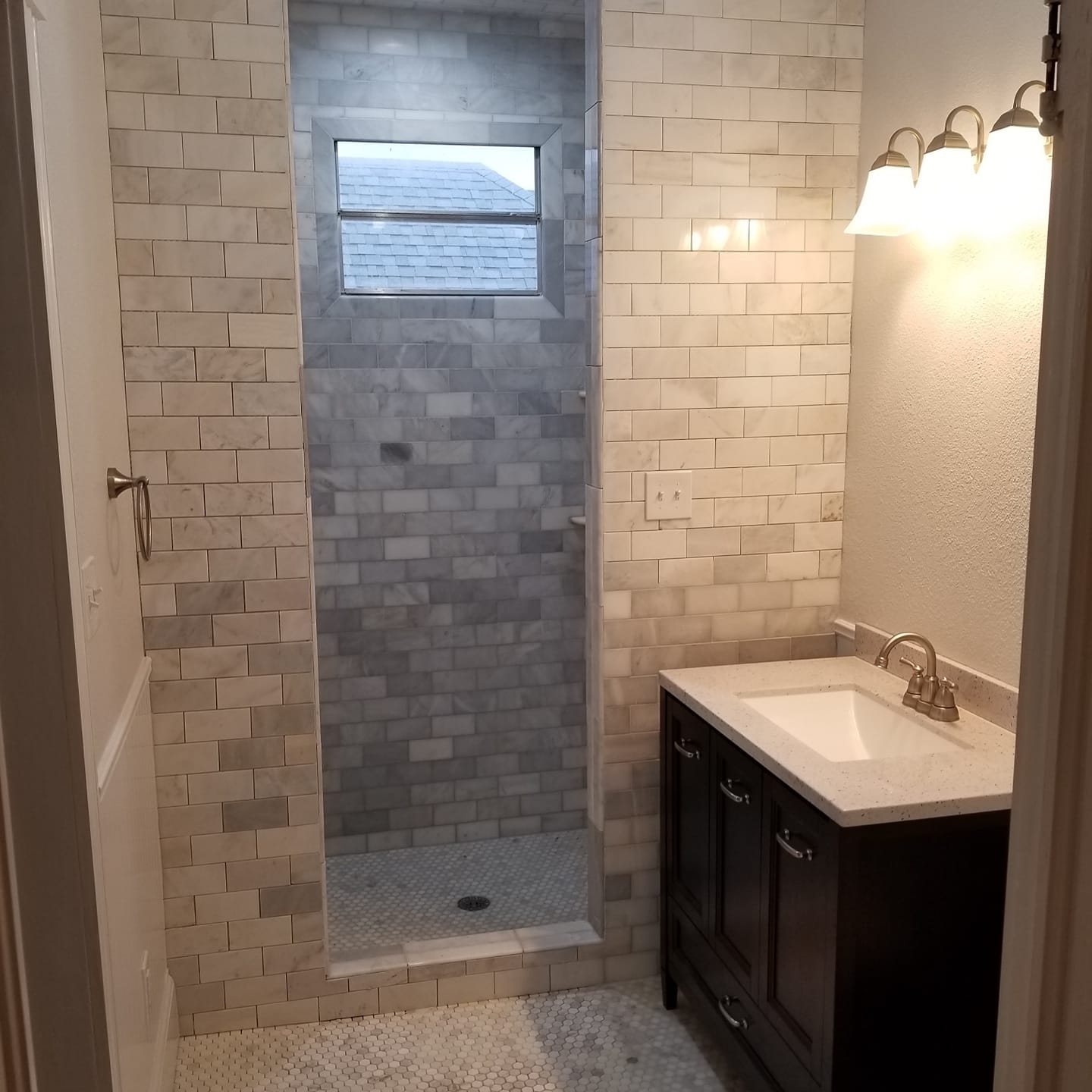 A bathroom with a sink and a walk in shower