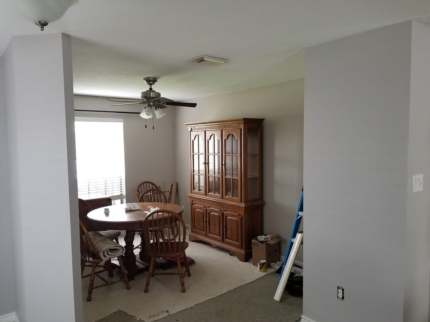 A dining room with a table and chairs and a ceiling fan.