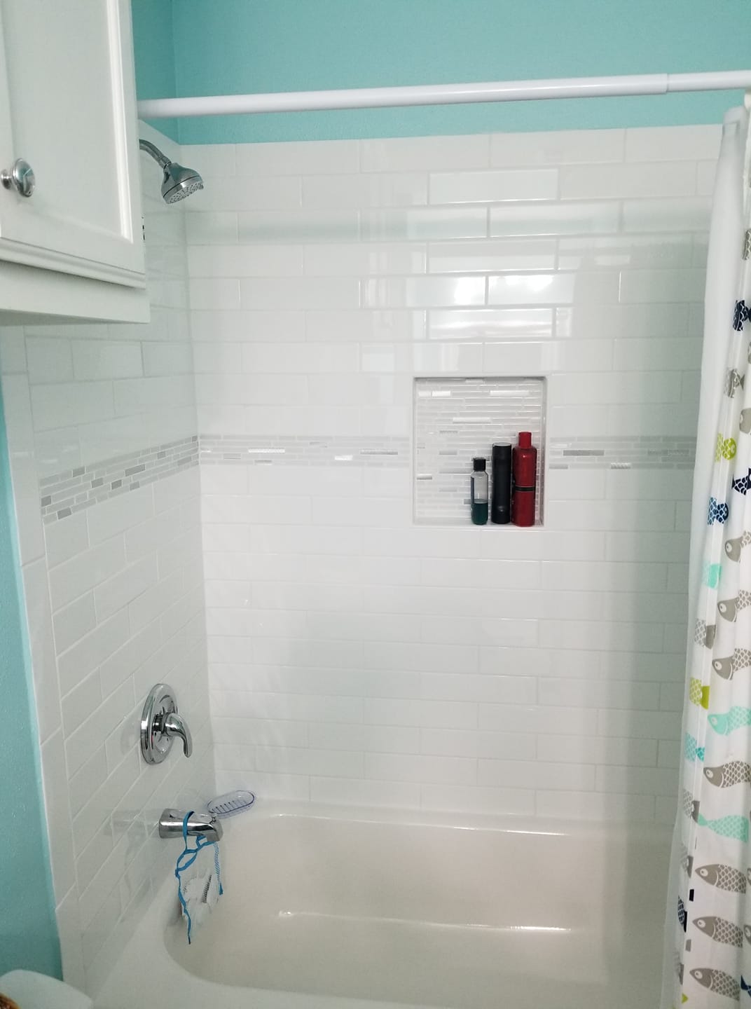 A bathroom with a bathtub , shower , and toilet.