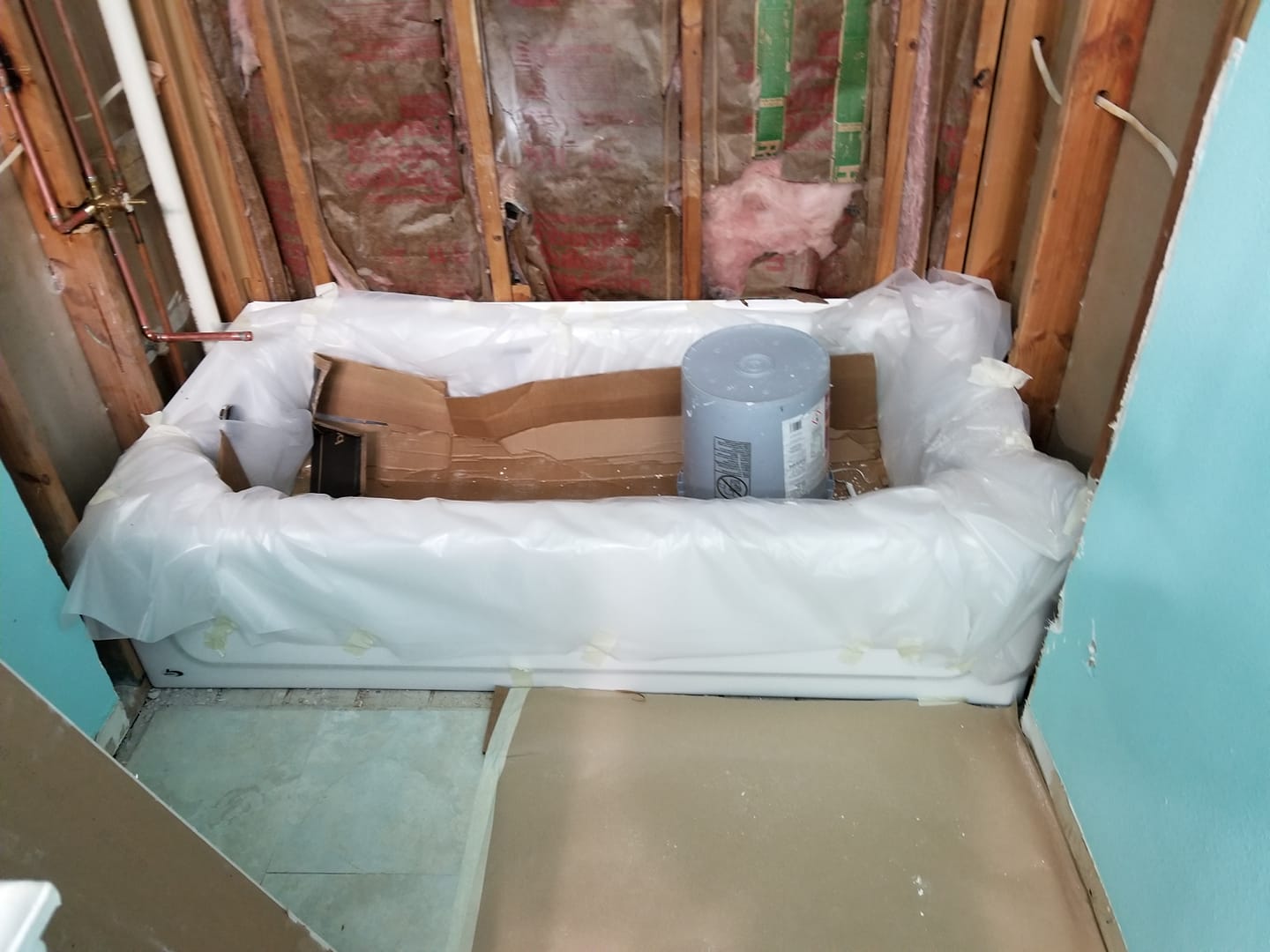 A bathtub is being remodeled in a bathroom.