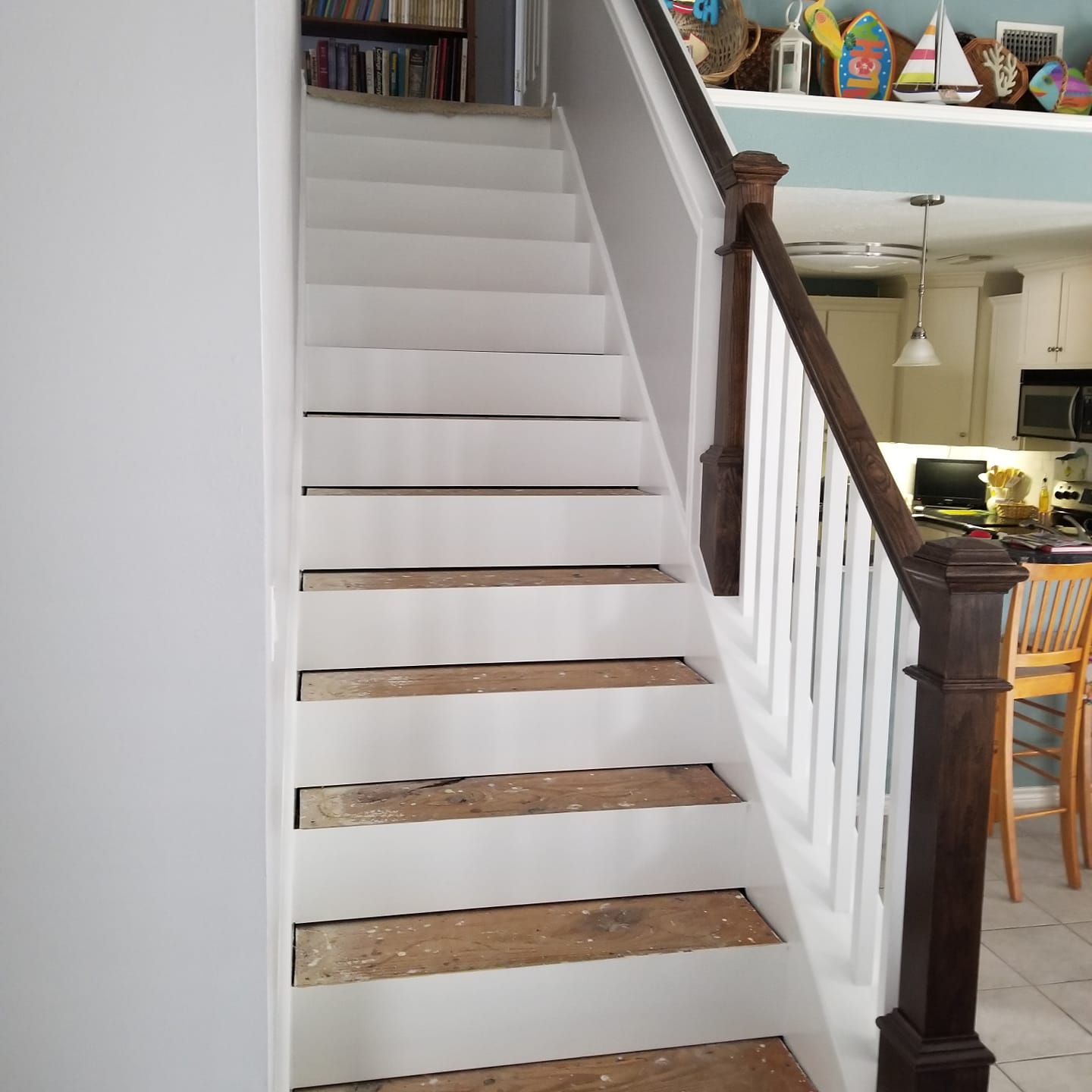 A white staircase with a wooden railing in a house