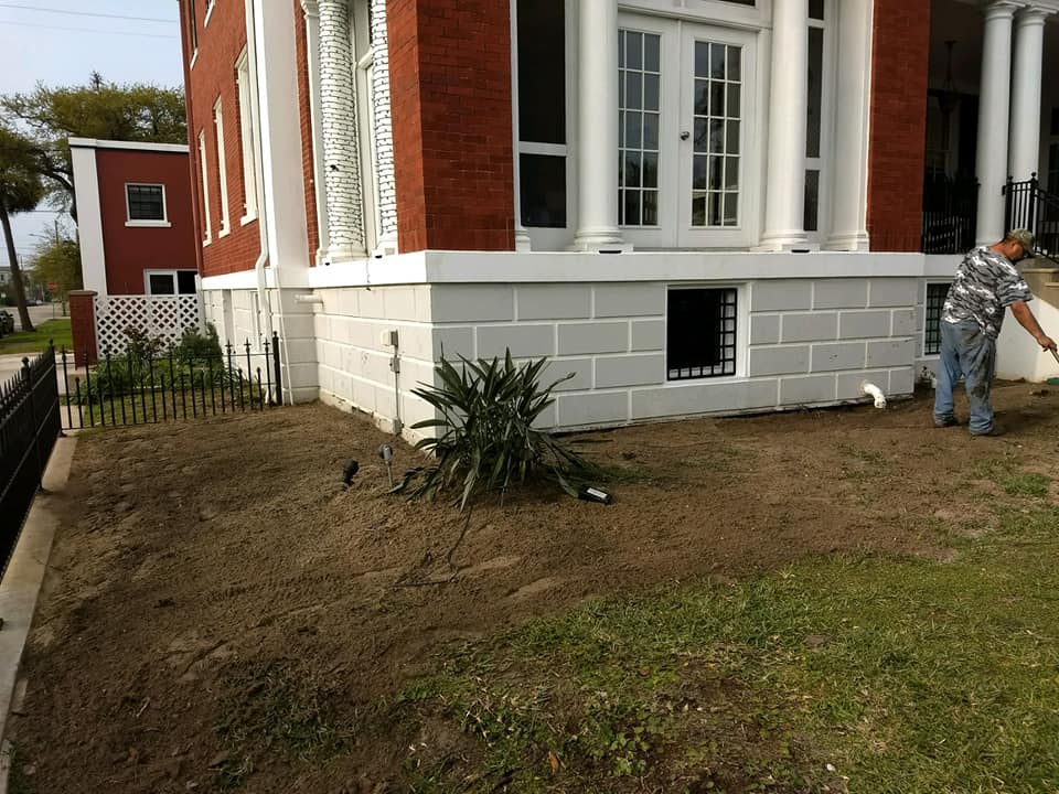 A man is standing in front of a large brick building