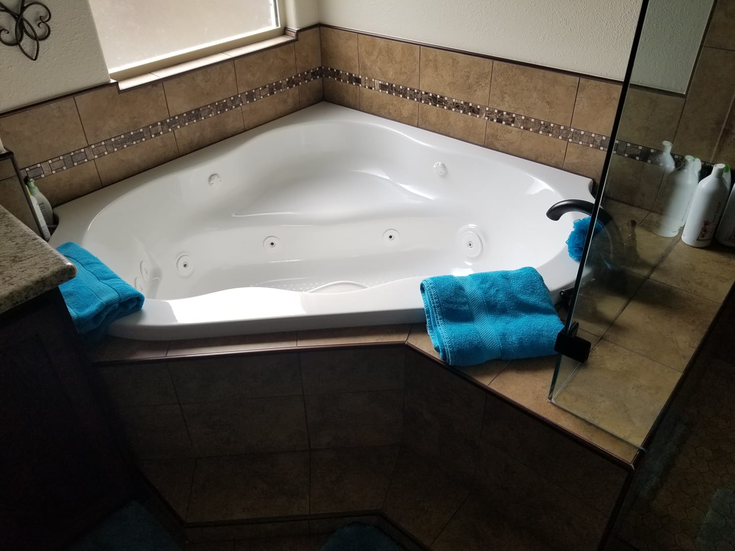 A bathroom with a jacuzzi tub and blue towels