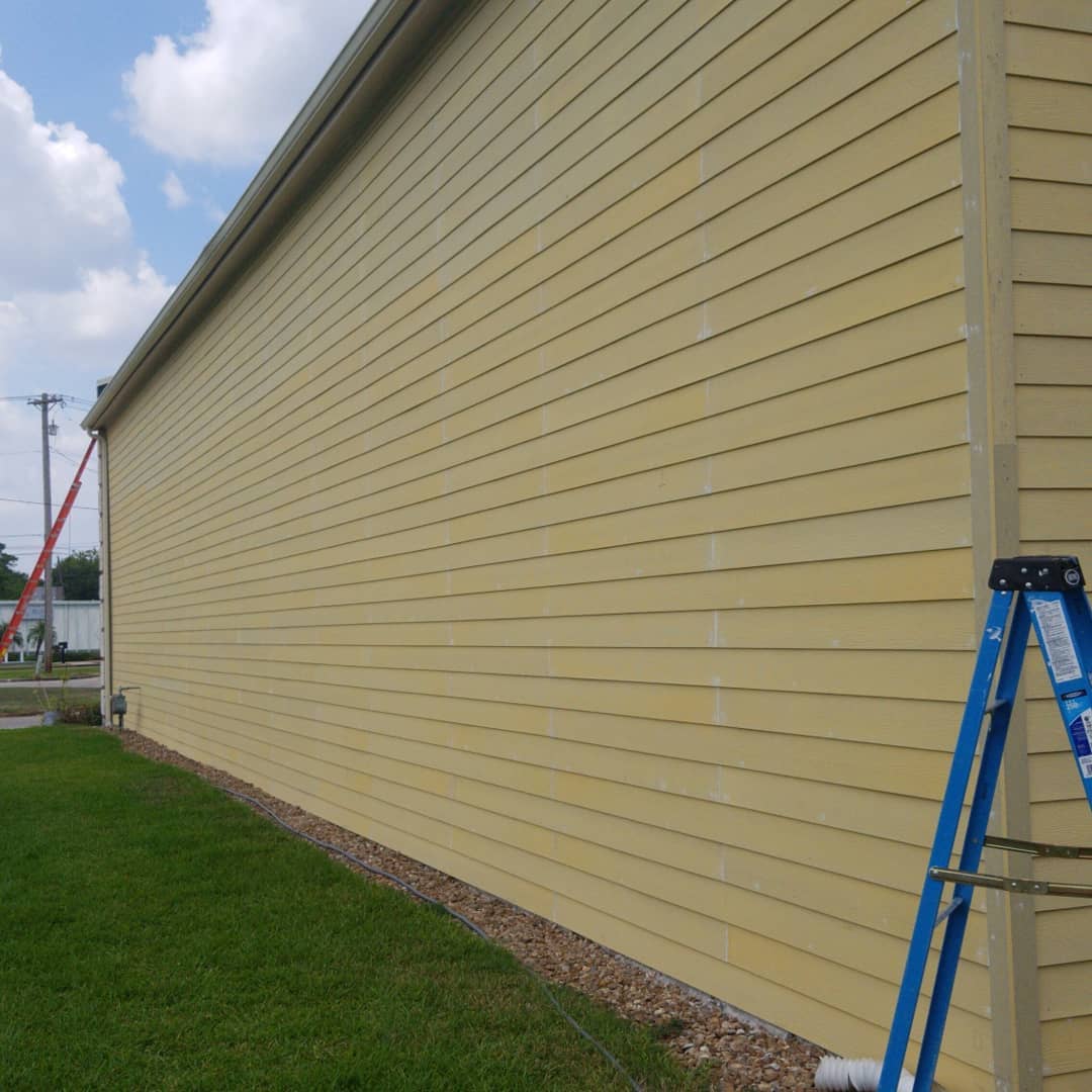A blue ladder is leaning against the side of a building