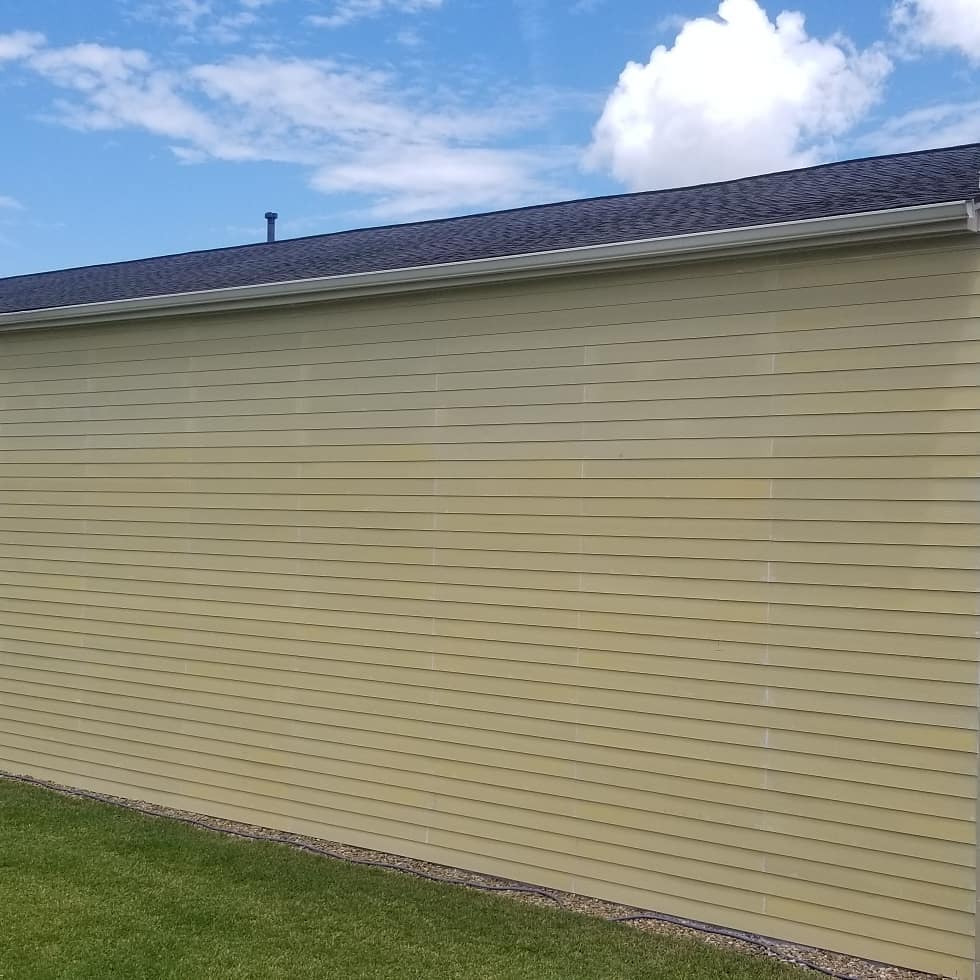 A house with a roof and siding on a sunny day.