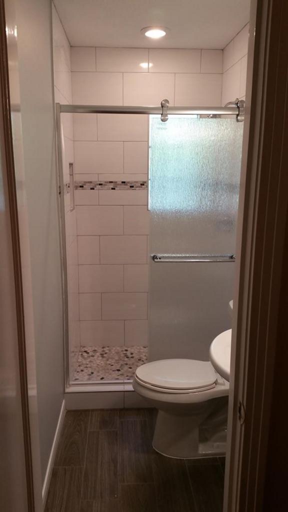 A bathroom with a toilet and a shower stall.