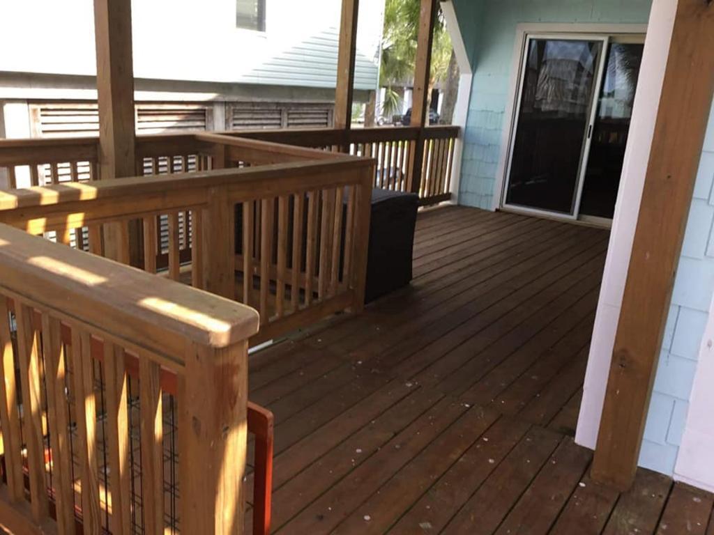 A large wooden deck with a sliding glass door