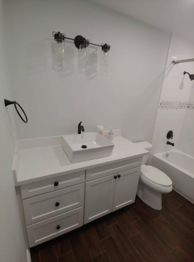A bathroom with a sink , toilet , and bathtub.