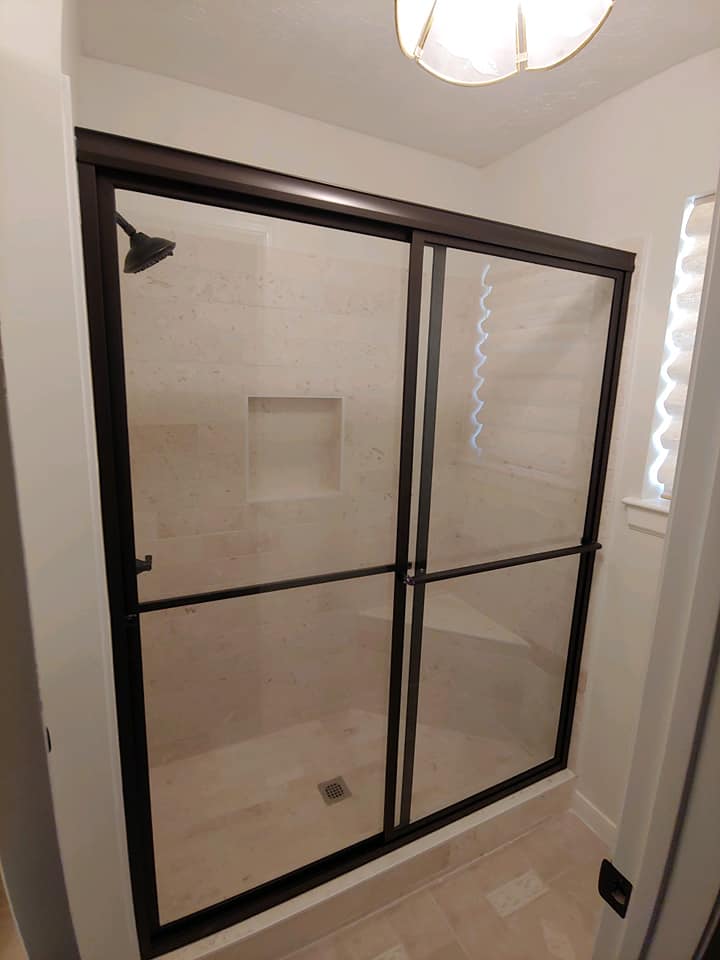 A bathroom with a sliding glass shower door and a shower head.