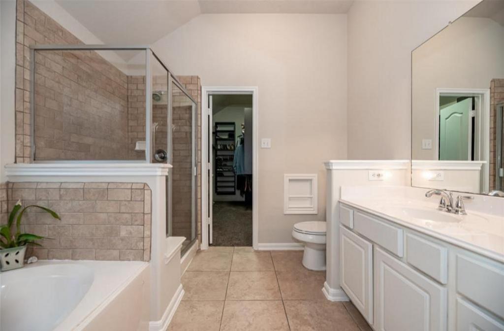 A bathroom with two sinks , a toilet , and a walk in shower.