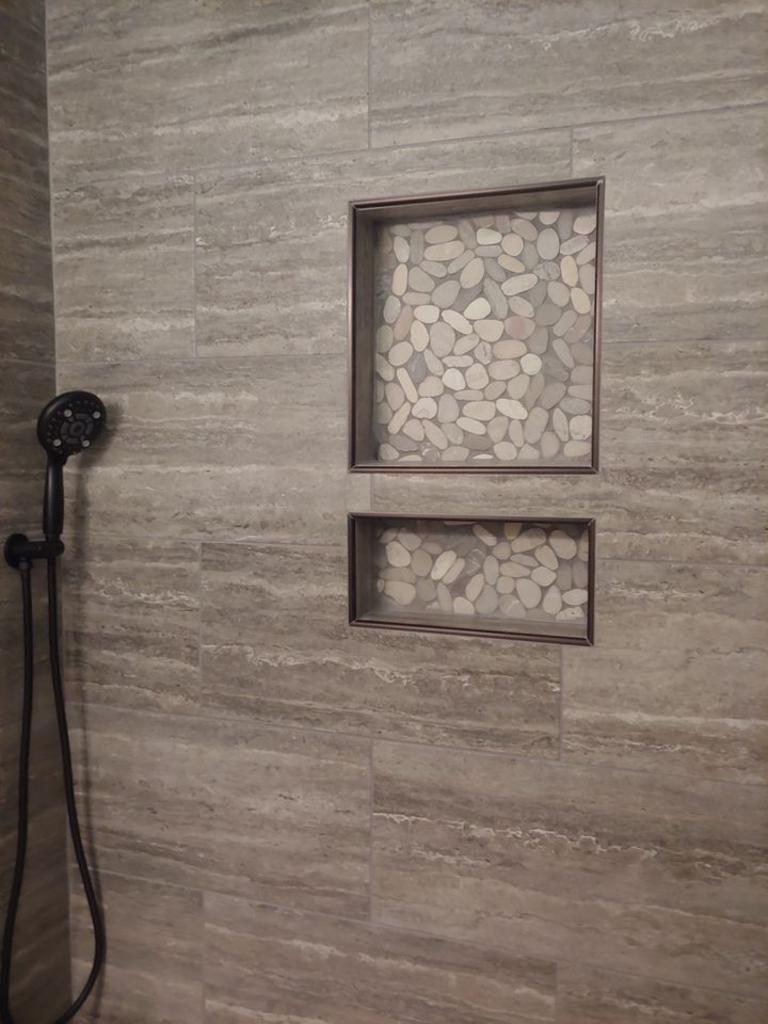 A shower with two niches and a shower head.