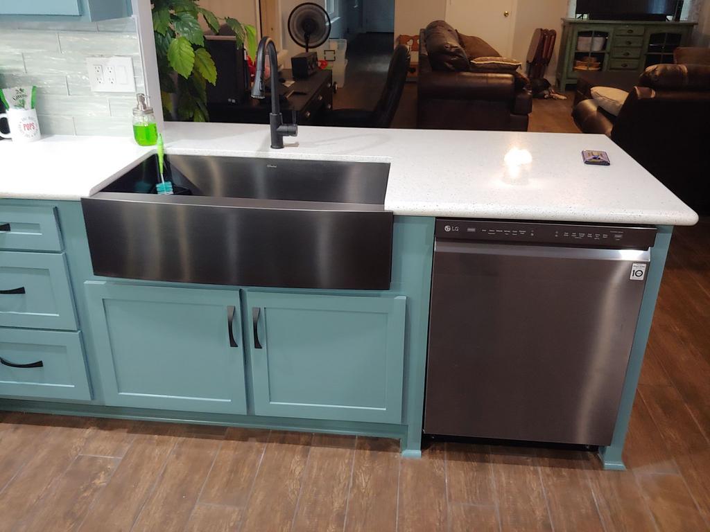 A kitchen with a stainless steel sink and a stainless steel dishwasher.