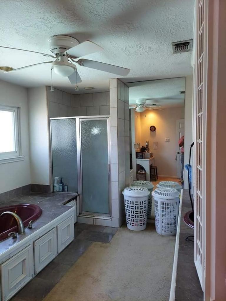 A bathroom with two laundry baskets and a ceiling fan